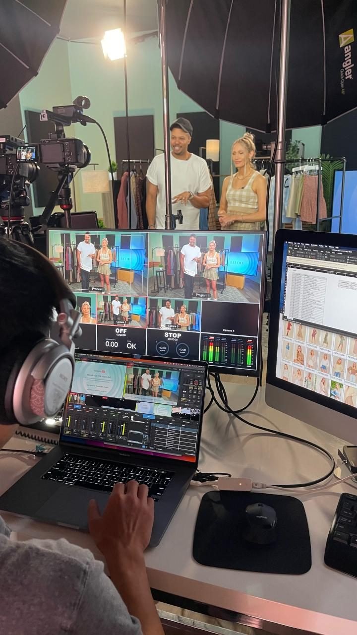 J Alexander on set hosting FashionGo LIVE with a co-host, cameras and monitors in front